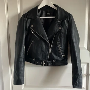 Svart skinnjacka från ONLY - Skinnjacka från ONLY med flera dragkedjor