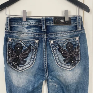 Miss Me jeans low rise/mid rise bootcut - Säljer dessa low rise/mid rise bootcut jeans från Miss Me i storleken 26 (motsvarar S). Defekter: hål nere vid hälen då dem e lite för långa för mig som e 168. Också lappade av skräddare mellan bena pga att byxorna är för små på mig som är i storlek M (därav säljer jag dem). Lappningen mellan bena är ingenting som syns när man går☺️