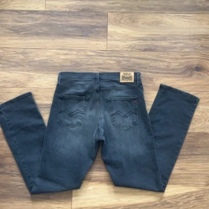 Replay svarta jeans straight fit - Snygga svarta jeans från Replay med klassisk femficksdesign och raka ben. Jeansen har en diskret tvättad look, svarta sömmar och Replay-lapp bak i midjan. Materialet är mjukt och stretchigt jeans, perfekt för en avslappnad stil.