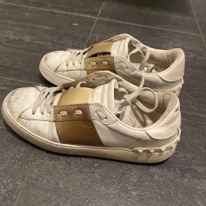 Valentino Open sneakers i vitt och guld - Jag säljer mina valentino open skor i använt skick men går att göra super fina med lite städande! Sitter som 38