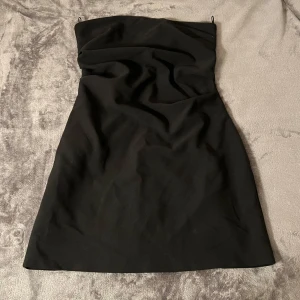 Svart axelbandslös klänning från Zara - Snygg svart axelbandslös kortklänning från Zara! Använd fåtal gånger 