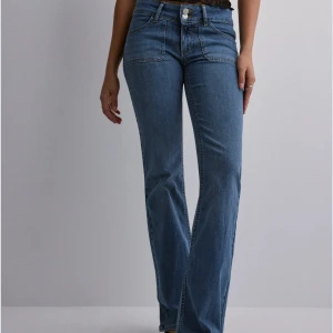 Blå lågmidjade bootcut jeans från Nelly - Supersnygga lågmidjade jeans från Nelly med dubbla knappar i midjan som är slutsålda i färgen mellanblå! använda fåtal gånger🫶