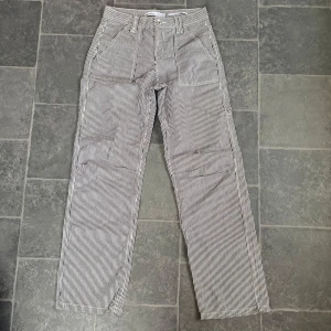 Berskha byxor  - Snygga, randiga byxor från Bershka i storlek 34. Perfekta för en avslappnad men trendig look. Byxorna är i nyskick och har en bekväm passform.