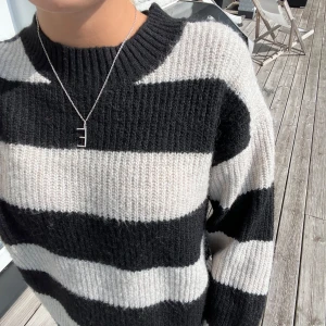 Randig stickad tröja  - Randig tröja i svart och beige/cremevit som knappt är använd. Den är i storlek xs men passar även m. 