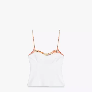 Vit linnetopp med blommiga detaljer - Snygg vit linnetopp med tunna axelband och blommigt mönster längs kanten och banden. 