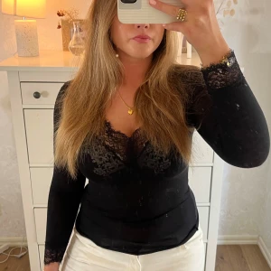 Svart långärmad topp  - Säljer en svart långärmad topp med snygga spetsdetaljer. Finns defekter men inget man tänker på💌