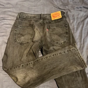 Levi's 501 grå jeans straight fit, storlek W: 29 L: 30 - Säljer ett par klassiska Levi's 501 jeans i grå tvätt med straight fit. Jeansen har fem fickor, knappgylf och den ikoniska läderpatchen bak i midjan. Perfekt för dig som gillar en tidlös och chill look. Passar till sneakers eller boots. Köpt i Levis butik. Köpte för 1 150kr.