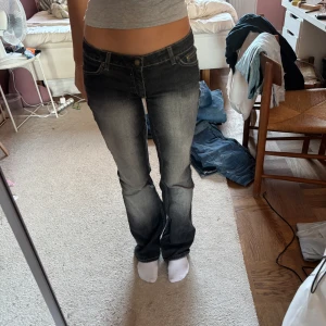Svarta bootcut jeans - Säljer ett par svarta  urtvättade bootcut jeans. Uppsydda i midjan 