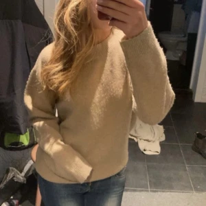 Beige stickad tröja med rund hals - Mysig beige stickad tröja med rund hals och långa ärmar. Tröjan är i väldigt bra skick och har inga defekter! Skriv prov för frågor💖