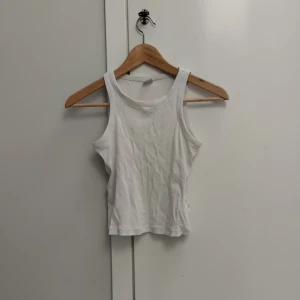 Vitt linne från Lindex  - Vitt linne i stretchigt material från Lindex. Storlek 146 / 152. Är ribbstickat i materialet, har en liten röd  fläck på ena sidan, men märks knappt. Säljer då det blivit för litet, köparen står för frakten och priset kan såklart diskuteras!