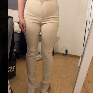 Beiga högmidjade bootcut byxor - Snygga beiga byxor med hög midja och bootcut-snitt. 