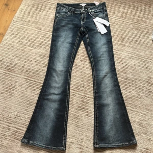 Blå flare jeans med broderade fickor S - Säljer dessa helt nya mörkblå flare jeans med snygg broderad design på bakfickorna och markerade sömmar med låg midja och utsvängda ben. Säljer dessa pga storleken inte passade, helt NYA utan någon alls använding.