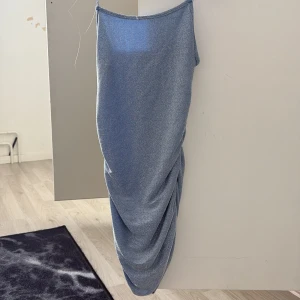 Blå långklänning från SHEIN XS - Snygg blå långklänning från SHEIN i storlek XS Petite. Klänningen har tunna axelband och ett coolt draperat fall längs sidan. Materialet är mjukt och stretchigt, tillverkat av polyester och elastan. Perfekt för dig som gillar minimalistisk stil med en twist.