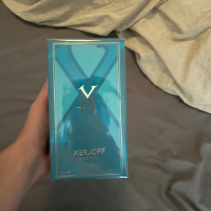 Xerjoff Erba Pura Eau de Parfum - Lyxig parfym från Xerjoff, Erba Pura, i en snygg turkosblå kartong med guldiga detaljer och stor X-logga. Flaskan innehåller 100 ml Eau de Parfum och levereras i originalförpackning. Perfekt för dig som gillar exklusiva dofter och stilren design.
