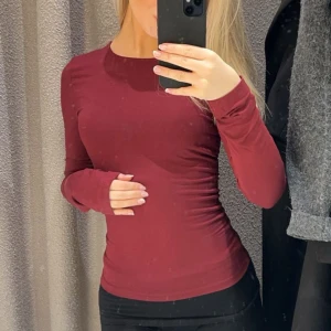 Vinröd långärmad topp Gina Tricot - Säljer en vinröd långärmad topp med tight passform. Toppen har rund halsringning och är tillverkad i ett mjukt, stretchigt material som sitter snyggt mot kroppen. Perfekt ny till hösten💗