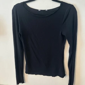 Svart långärmad topp - En enkel svart långärmad topp från intimissimi(liknande) med rund halsringning. Tunn och mjuk i materialet, perfekt att ha som basplagg eller under en kofta. Passformen är normal och modellen är rak och tajt