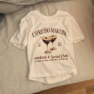 Vit t-shirt med print - Vit t-shirt med tryck av två espresso martinis och texten 'Espresso Martini cocktail & Social Club'. T-shirten har rund hals och korta ärmar, perfekt för dig som gillar coola och trendiga motiv. I bra skick 💖