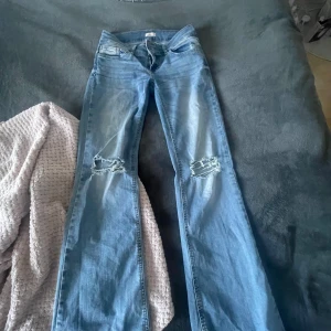 Blå bootcut jeans från Nelly - Säljer ett par lågmidjade trendiga jeans från NELLY i storlek 36 pga att de tyvärr blivit för små
