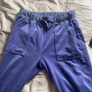 Lila mjukisbyxor från Instinct - Säljer ett par lila mjukisbyxor från Instinct med bred resår och dragsko i midjan. Byxorna har stora fickor fram och bakfickor med lock och knapp. Perfekta för en avslappnad stil. Är köpta för 300. Pris kan diskuteras