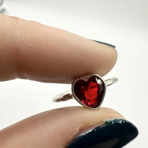 Romantisk handgjord ring med hjärtformad granat – silverpläterad ny och oanvänd present gåva - Handgjord och vackert formad ring i silverpläterad metall med gnistrande hjärtformad granatsten. Storlek ca 17 mm i innerdiameter. I nyskick! Granat sägs symbolisera kärlek, mod och passion – en perfekt detalj med mening.  Ingen prutning – bundlerabatt erbjuds. Jag rensar smyckesskrin och garderob, så passa på att kika på mina andra annonser också! Ny och oanvänd.  ⸻ 