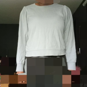 Ljusblå långärmad tröja från KappAhl - Säljer en enkel och stilren ljusblå långärmad tröja från KappAhl. Tröjan har en rund halsringning och lätt puffade axlar för en modern touch. Perfekt att matcha med jeans eller kjol.