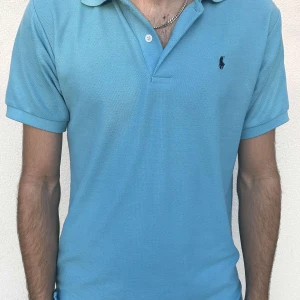 Turkos Ralph & Lauren Piké - Väldigt fin piké tröja från Ralph lauren. Färgen är turkos och tröjan är lite nopprig som den blir när man använt den, men inte överdrivet mycket så skicket är fortfarande väldigt bra! Perfekt till sommaren och våren!