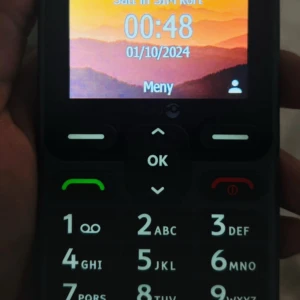 Doro mobiltelefon med stora knappar - Enkel mobiltelefon från Doro med stora, tydliga knappar och färgskärm. Perfekt för dig som vill ha en lättanvänd telefon utan krångel. Telefonen har en svart design och tydliga symboler på knapparna. Laddare ingår