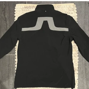 Svart vindjacka från J.Lindeberg - Snygg svart vindjacka från J Lindeberg i storlek L men sitter som en M/S. Skriv om ni har frågor eller vill se fler bilder. Jackan är i nästintill helt nytt skick och har inga tecken på användning. Priset går att diskutera.