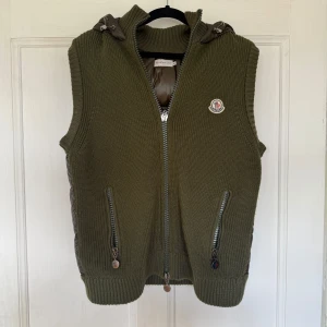 Olivgrön stickad dunväst från Moncler - Snygg olivgrön dunväst från Moncler. Bra och fint skick. Storlek M. Är 183 o lite för liten för mig. Ba o skriva om några frågor. Äkta såklart.