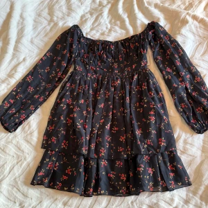 Blommig klänning - Supersöt svart klänning från NA-KD med blommigt mönster. Strlk 38 men passar både 38 och 36, aldrig använd. 220kr inkl. Frakt