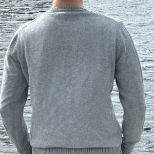 Grå stickad tröja från Morris - Säljer en grå stickad tröja från Morris med texten 'Morris Rowing Club' och ett litet emblem på bröstet. Tröjan har rund halsringning och ribbade muddar vid ärmslut och nederkant. Perfekt för en stilren och avslappnad look. Priset kan diskuteras vid en snabb affär. Tveka inte att höra av er vid minsta fundering🥂