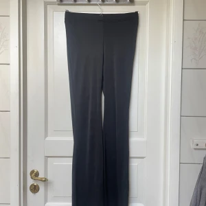 Svarta vida byxor - Säljer ett par svarta byxor med vida ben och hög midja. Byxorna har en stilren och enkel design utan synliga detaljer och är perfekta för en clean look. Materialet känns mjukt och följsamt.