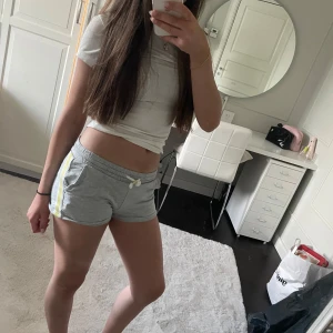 Gråa pyjamas shorts  - Gråa pyjamas shorts med gul sida. Bra skick. Använd några gånger. Stl 134/140