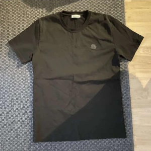 Svart t-shirt från Moncler - Säljer en svart t-shirt från Moncler med rund halsringning och diskret Moncler-logga på bröstet. T-shirten har en klassisk passform och är tillverkad i mjuk bomull. Perfekt för en stilren och enkel look. Skriv för fler bilder, eller några funderingar