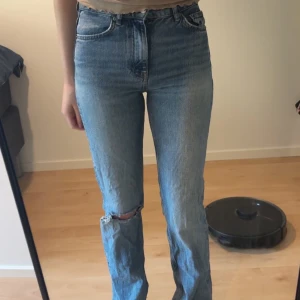 Blå jeans med hål från g perfect jeans - Säljer ett par klassiska blå jeans från g perfect jeans i storlek 32. Byxorna har medelhög midja, och ett hål i ena knät