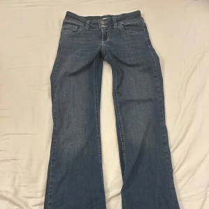 Blå bootcut jeans med låg midja - Jag har använt den 2 gånger, jag är väldigt lång så den passar inte riktigt! den är dessutom ny och ej utsliten 😊den är storlek 26 men passar om du är storlek 28!