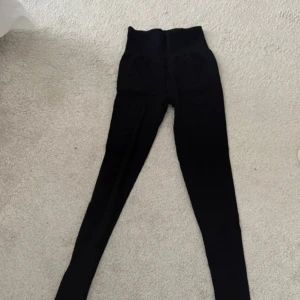Svarta leggings med hög midja - Svarta leggings med hög midja i stretchigt material. Tillverkade i Italien och består av 96% polyamid och 4% elastan. Perfekta för en bekväm och stilren look.