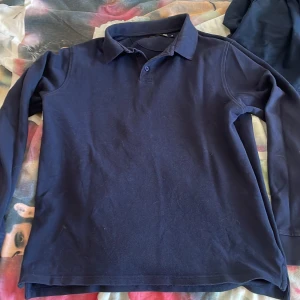 Mörkblå långärmad pikétröja - Säljer en stilren mörkblå långärmad pikétröja som  är perfekt för sommaren!