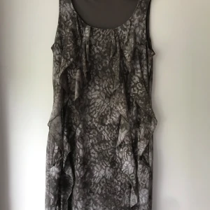 Gråmönstrad ärmlös klänning - Fin klänning i mönstrad animal print. Med volanger.