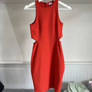 Röd ärmlös klänning från Gina Tricot - Säljer en snygg röd klänning från Gina Tricot i storlek XS. Klänningen är ärmlös med rund halsringning och har en tight passform. Materialet är strukturerat och stretchigt, perfekt för att sticka ut.