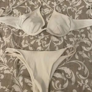 Vit ribbad bikini med bygel - Säljer en stilren vit bikini med ribbat material. Överdelen har bygel och tunna axelband. Underdelen har hög midja och smala sidor för en modern look.