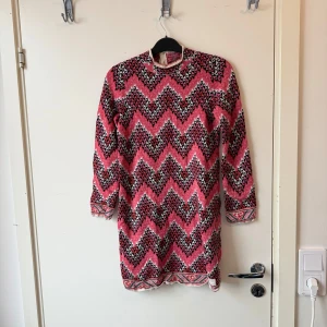 Mönstrad klänning från Odd Molly - Säljer en färgstark klänning från Odd Molly med zigzag-mönster i rosa, svart och vitt. Klänningen har lång ärm, rund hals och dragkedja i ryggen. Perfekt för dig som gillar unika plagg med mycket färg och mönster. Storlek 0 som enligt deras storleksguide motsvarar ungefär en Storlek XS. Mycket fint skick, jag hittar inga synliga anmärkningar eller defekter.  
