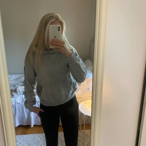 Grå hoodie från C - Säljer en enkel och stilren grå hoodie från Cubus i storlek 146/152. Tröjan har huva och en klassisk känguruficka framtill. Perfekt för en avslappnad och bekväm stil.