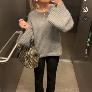 Grå stickad tröja By Malene Birger - Mysig grå stickad tröja från By Malene Birger med rund halsringning och breda ribbade muddar vid ärmsluten. Nypris är runt 3000kr