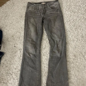 Grå bootcut jeans från Gina Tricot - Säljer ett par grå jeans från Gina Tricot i storlek 164. Byxorna har bootcut-modell och är low/mid waist med klassiska fickor fram och bak, samt snygga sömdetaljer. Säljer för att de är för små. Bra skick. 