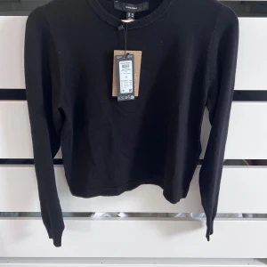 Svart stickad tröja från Vero Moda - En klassisk svart stickad tröja från Vero Moda i storlek XS. Tröjan har rund halsringning, ribbade muddar och lång ärm. Perfekt för lager-på-lager och enkel att matcha med allt. Snygg och stilren basic som funkar året runt.