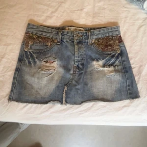 Jeanskjol med detaljer  -  ÖPPEN FÖR PRIS DISKUSSION‼️💗Snygg ljusblå jeanskjol från Pure Oxygen med slitna detaljer och rå kant nertill. Fickor fram och bak, samt paisleymönstrade tyginslag vid fickorna som ger en unik touch. Perfekt för dig som vill sticka ut med en cool och trendig look. Den är bra kvalitet och säljer för att den inte passar på mig💗💗