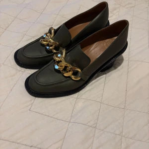 Gröna loafers med chunky guldkedja ATP i storlek 39 - Stilrena gröna loafers från ATP Atelier i skinn. Liten defekt vilken man kan se på sista bilden. Nypris runt 5000kr