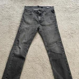 Replay grå jeans, smal passform - Snygga grå jeans från Replay i smal passform. Klassisk femficksmodell med svarta detaljer och diskret tvättad look. Perfekta för dig som gillar stilrena och bekväma jeans med modern känsla.