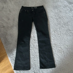 Svarta bootcut jeans från LTB  - Svarta jeans från LTB med bootcut passform. Klassisk femficksmodell med snyggt utsvängda ben och låg midja. Jeansen är tillverkade i bomull med en liten del elastan för extra stretch och bekvämlighet.